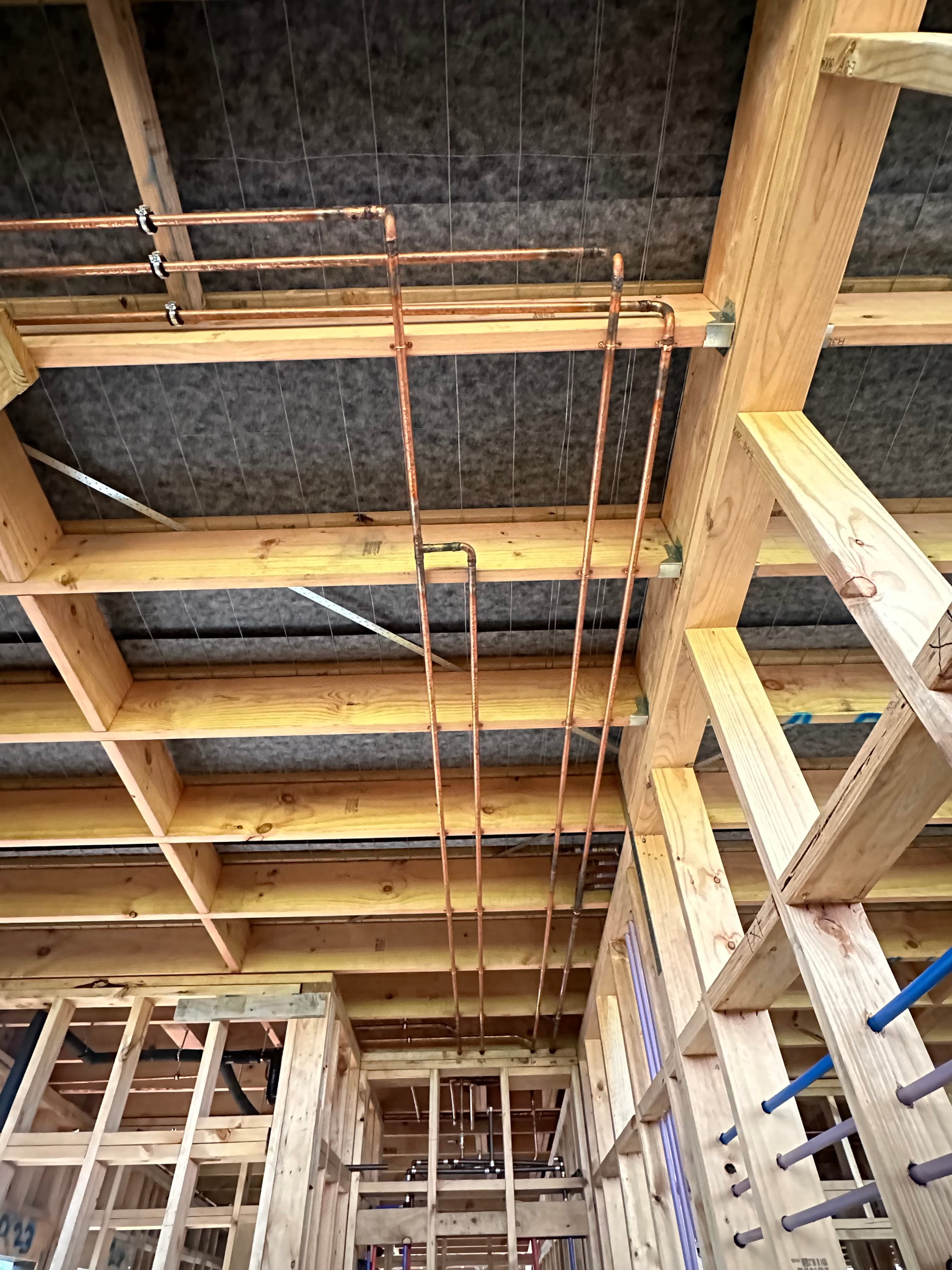 Copper pipe rough-in through ceiling joists during new build framing